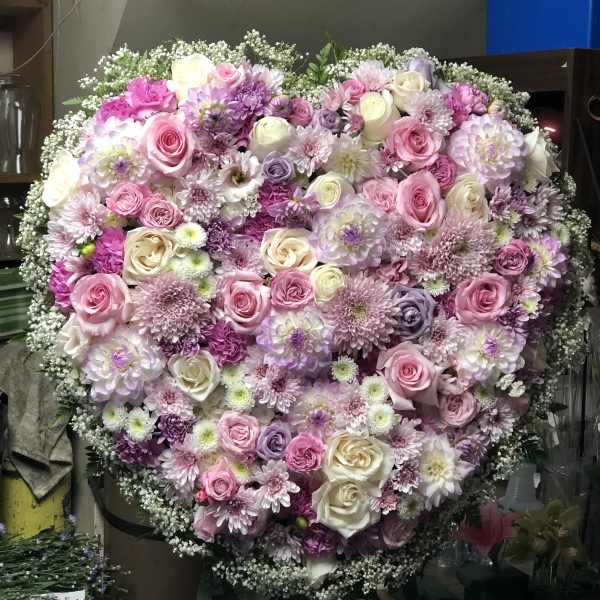 Large heart-shaped floral arrangement with pink, white, and lavender blooms