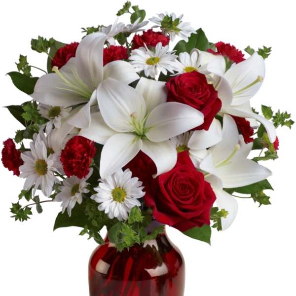 Red roses and white lilies in a red glass vase