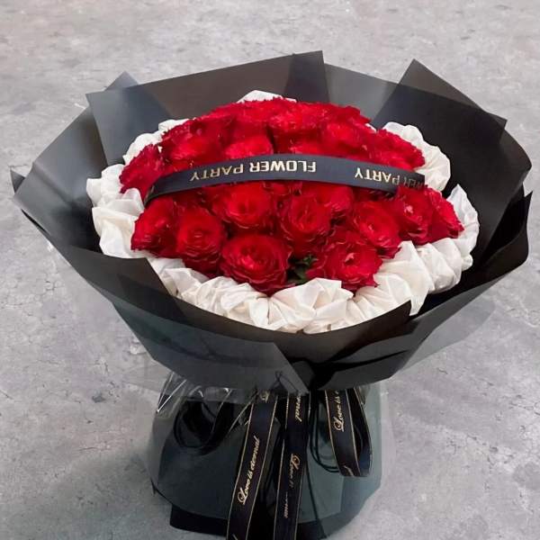 Bouquet of red and white roses wrapped in black paper