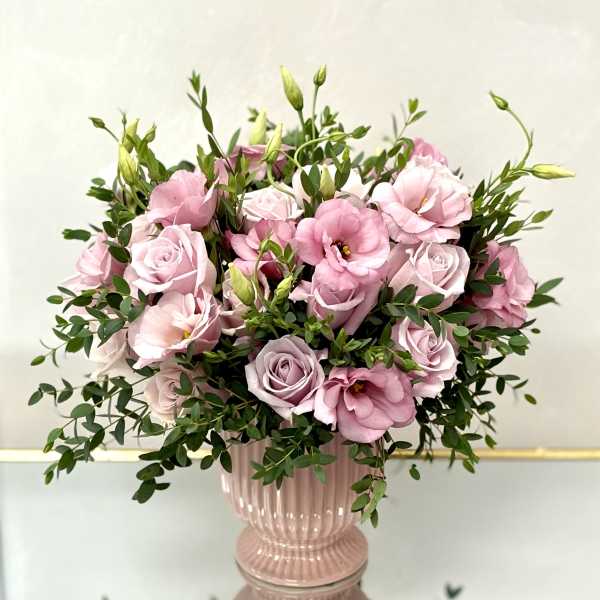 Pink roses and lisianthus in a pink glass vase