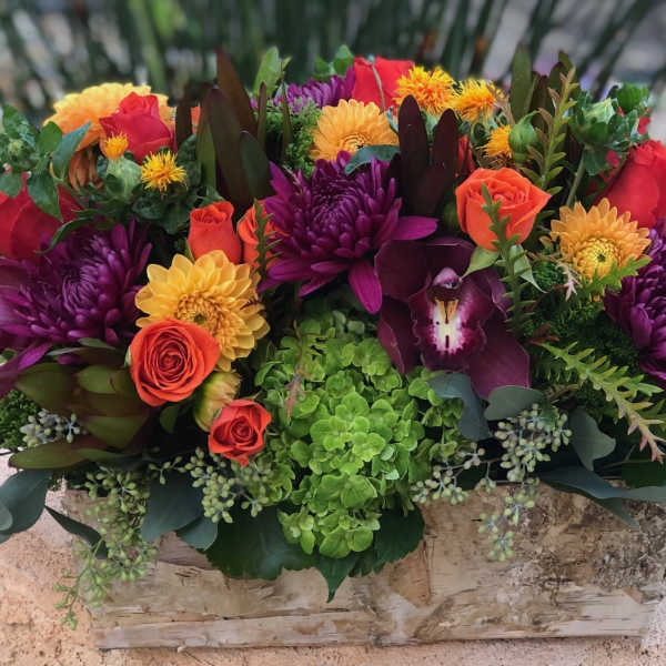 Colorful mixed flower arrangement in a rustic wooden box