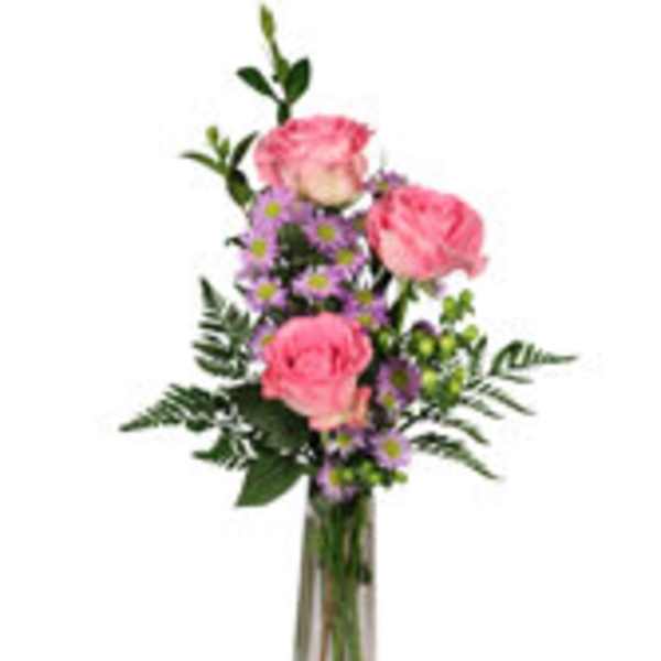 Pink roses and purple daisies in a tall glass vase