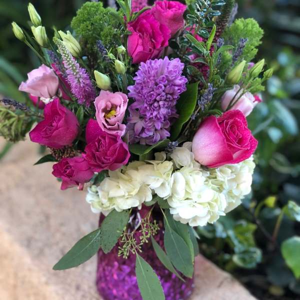 Pink and white mixed bouquet in a purple vase