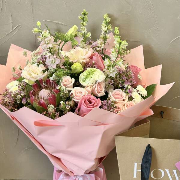 Pink bouquet with roses and mixed blooms wrapped in pink paper