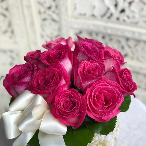 Bouquet of bright pink roses with a white ribbon bow