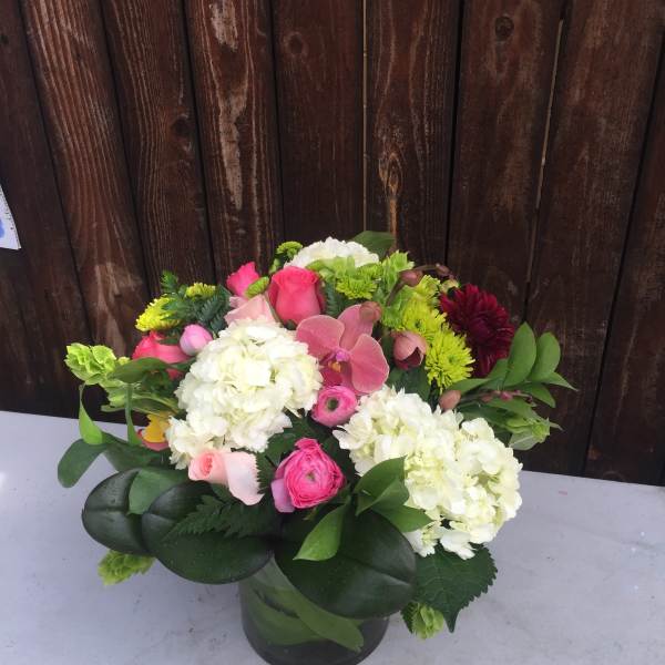 Pink and white floral arrangement in a glass vase