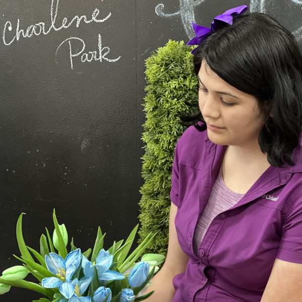 Woman holding a bouquet of blue flowers and green tulips