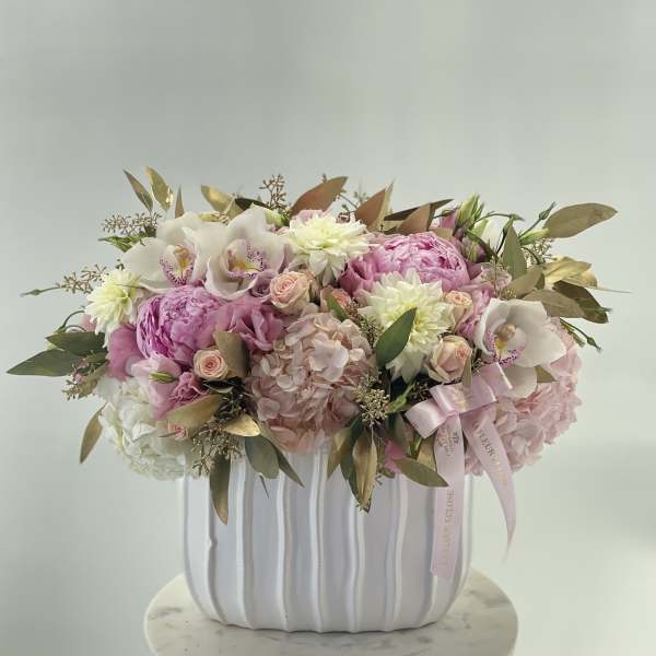 Pink and white floral arrangement in a white ribbed vase