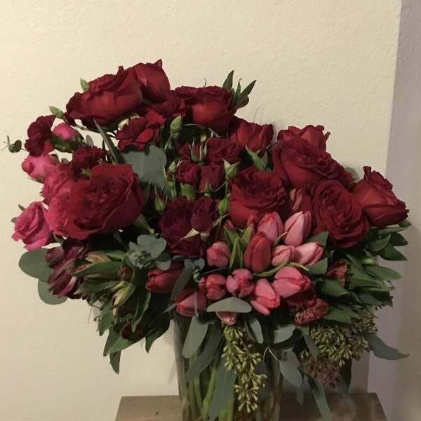 Bouquet of red and pink roses in a clear glass vase