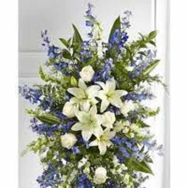 Tall white lily and blue flower standing spray on an easel