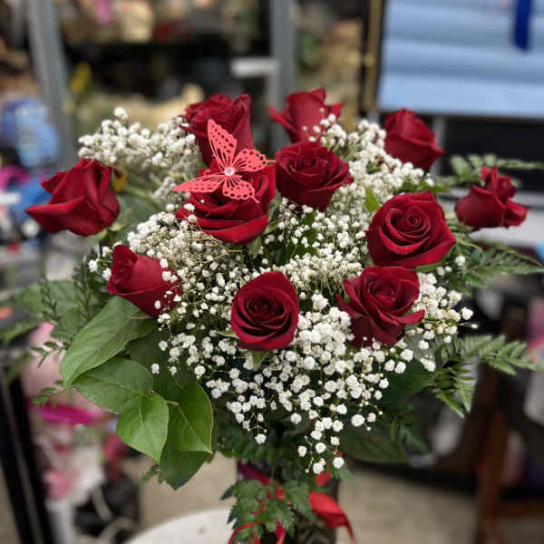 Bouquet of red roses with white baby's breath and a pink butterfly pick