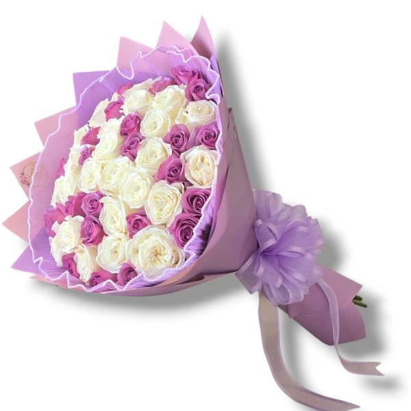 Bouquet of white and purple roses wrapped in lavender paper