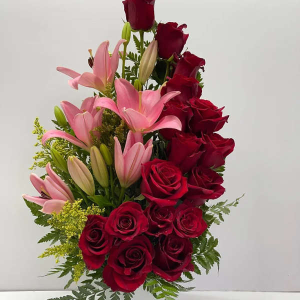 Red roses and pink lilies arranged in a white vase