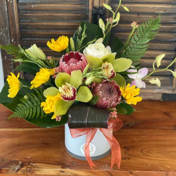 Mixed tropical bouquet in a white box with a coral ribbon