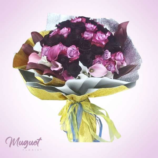 Bouquet of pink and dark roses with calla lilies wrapped in metallic paper