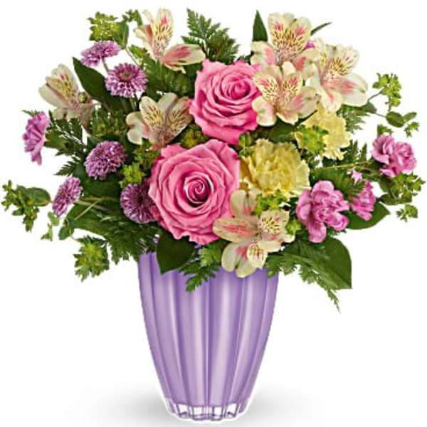 Pink roses and mixed flowers arranged in a purple vase