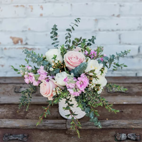 Pink and white floral arrangement in a white vase