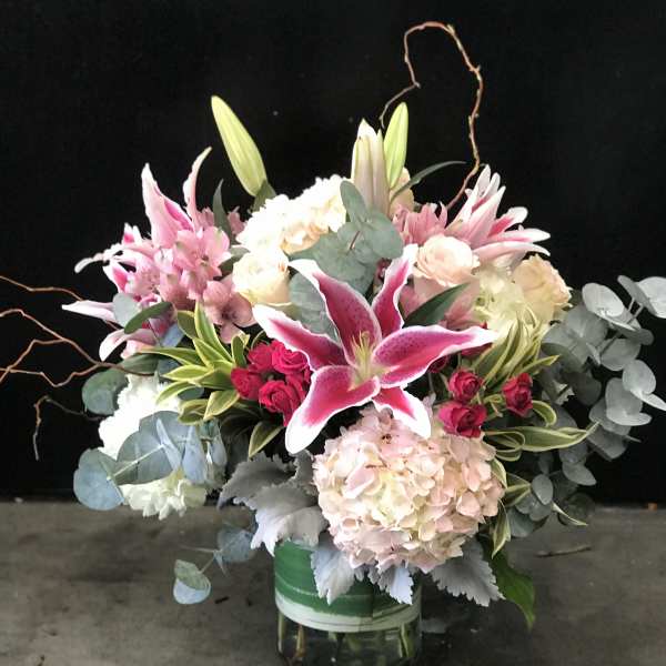 Pink lilies and hydrangeas in a glass vase