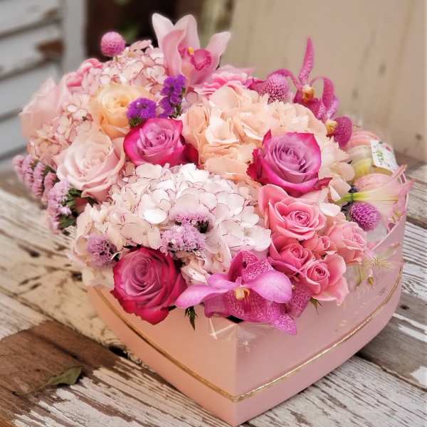 Pink and peach floral arrangement in a heart-shaped box