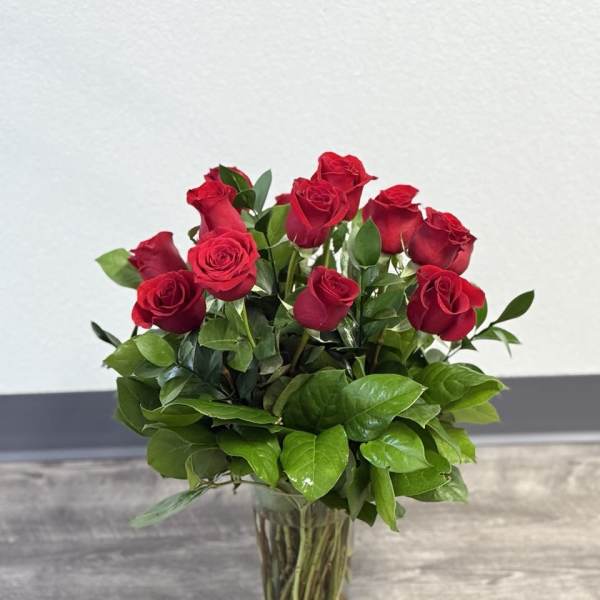 Red roses arranged in a clear glass vase