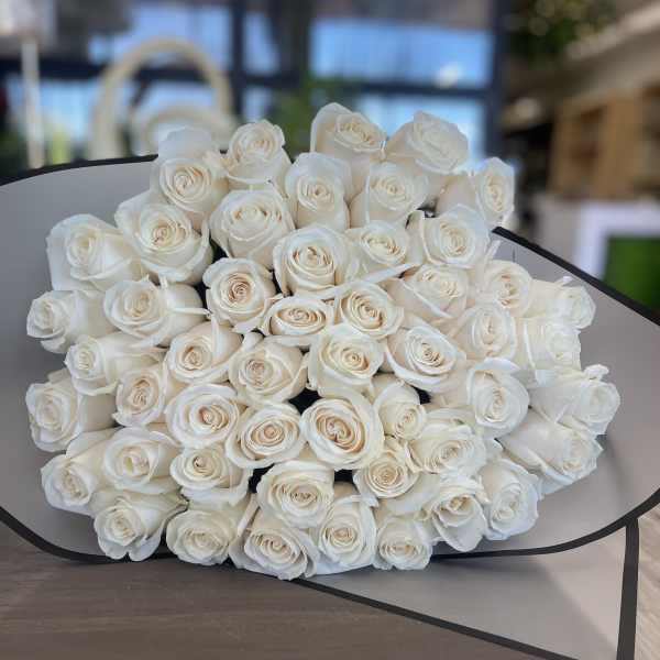 Large bouquet of white roses wrapped in gray paper