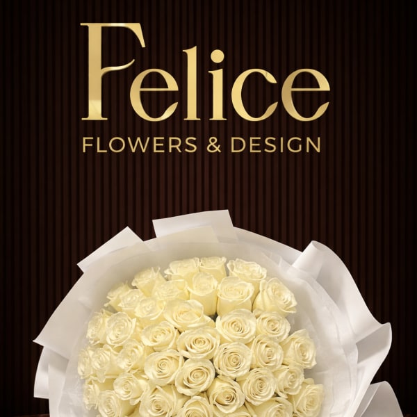 Bouquet of cream roses wrapped in white paper with a ribbon