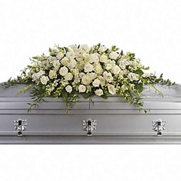 White floral casket spray on a silver casket