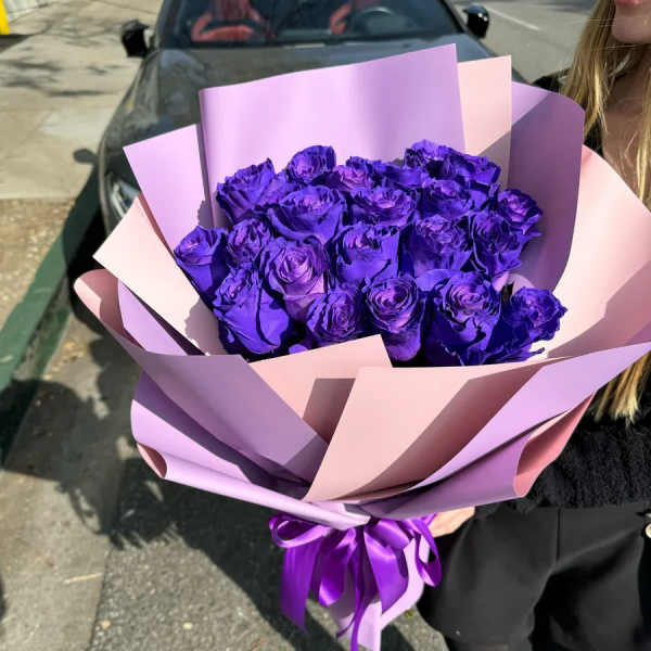 Bouquet of purple roses wrapped in pink and lavender paper