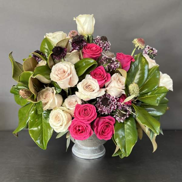 Bouquet of pink and cream roses in a silver vase