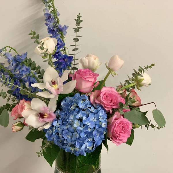 Pink roses and blue hydrangeas in a glass vase