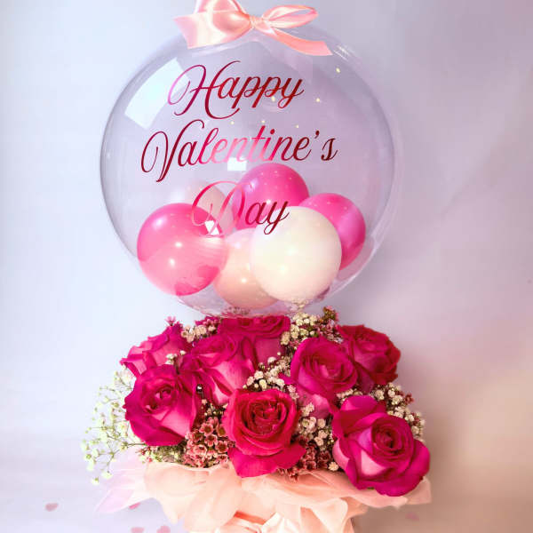 Pink rose arrangement with a clear balloon reading Happy Valentine's Day