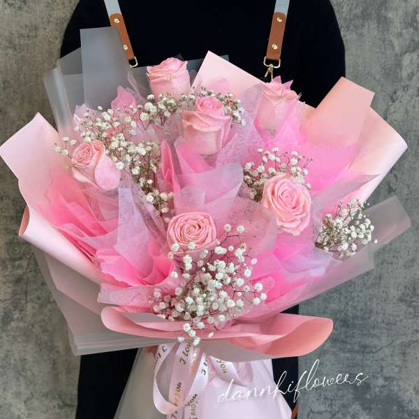 Pink rose bouquet with baby's breath in layered pastel wrapping