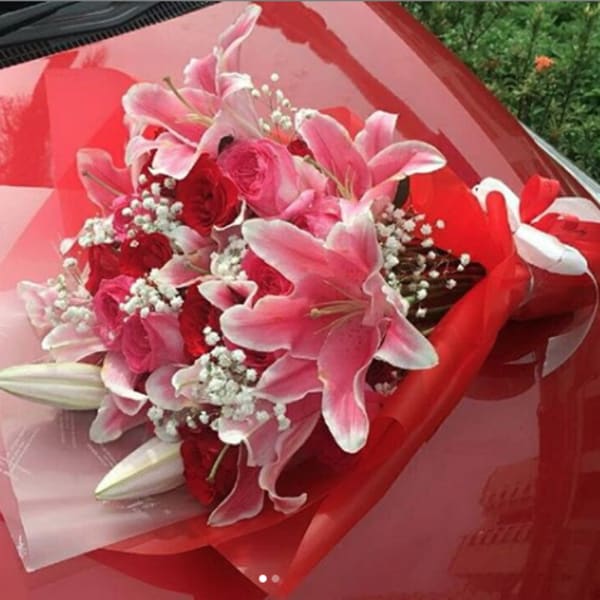 Pink lilies and red roses wrapped in red paper