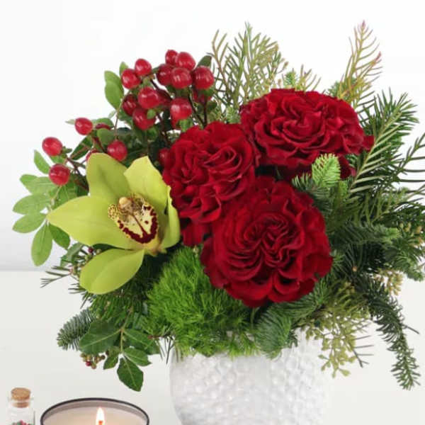 Red roses and a green orchid in a white vase