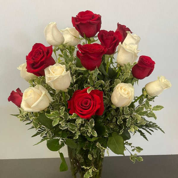 Red and white roses arranged in a clear glass vase