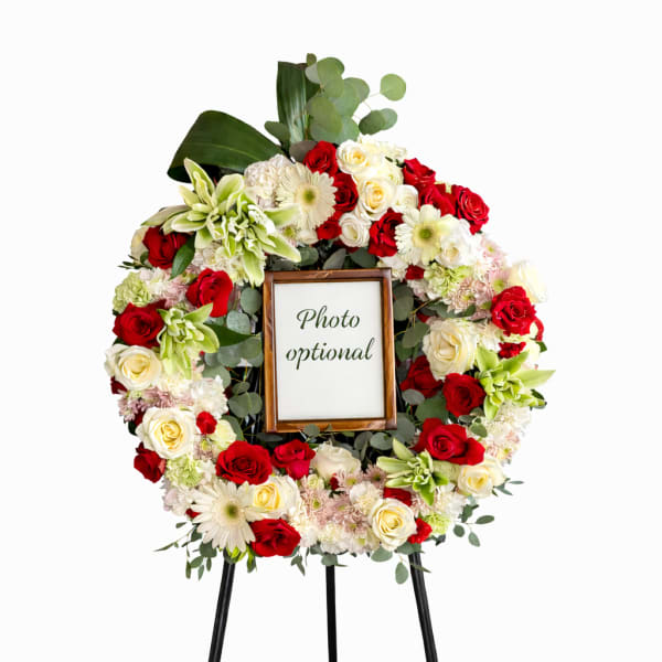 Floral wreath on a stand with a photo frame in the center