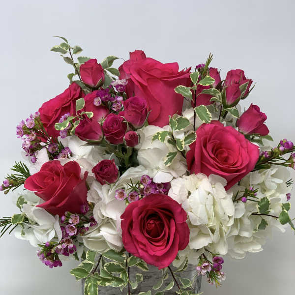 Pink roses and white hydrangeas in a square glass vase