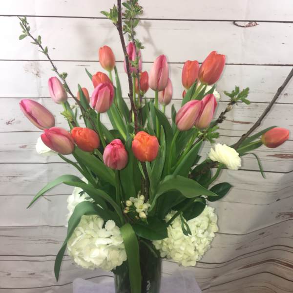 Tulip arrangement in a glass vase with white hydrangeas