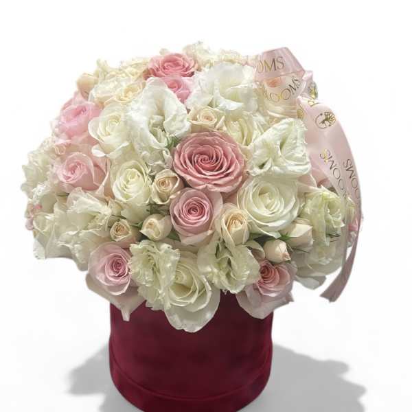 Pink and white roses arranged in a burgundy hatbox