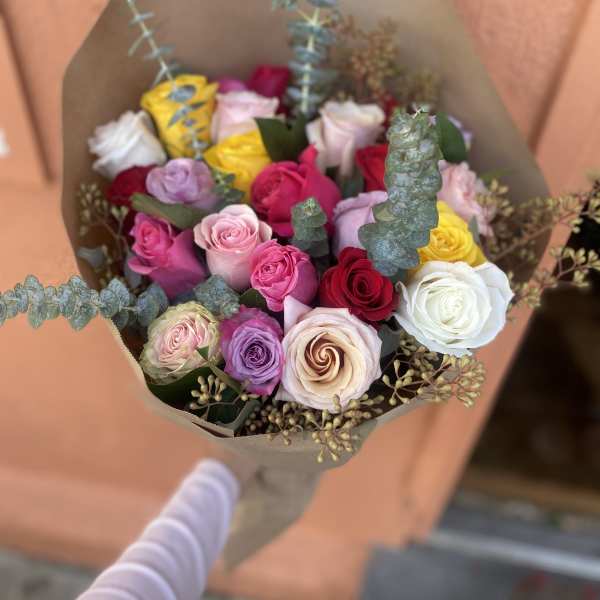 Bouquet of multicolored roses wrapped in brown paper