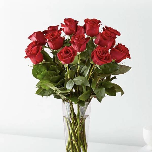 Red roses arranged in a clear glass vase