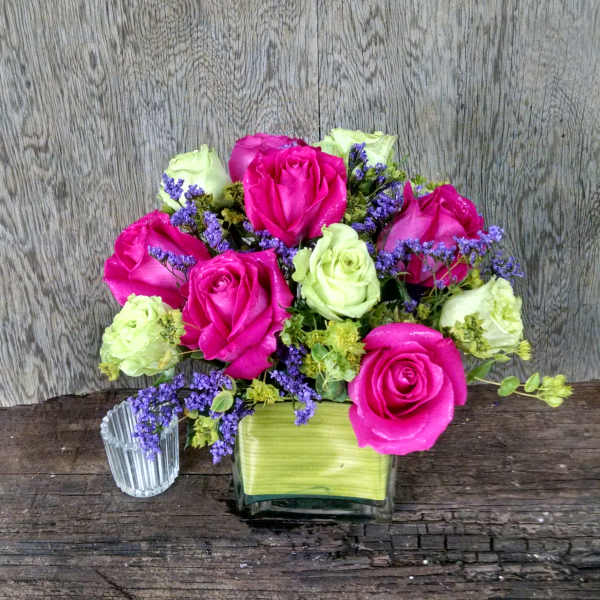 Pink and pale green roses in a square glass vase