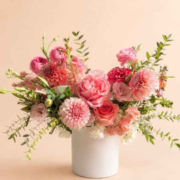 Pink and peach flower arrangement in a white vase