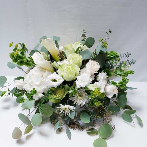 White and pale green floral arrangement with calla lilies and roses
