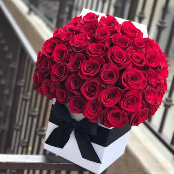 Bouquet of red roses in a white box tied with a black ribbon