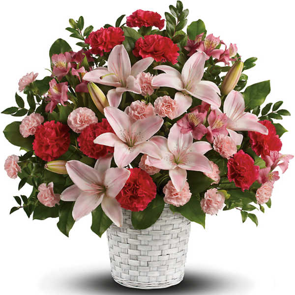 Pink lilies and carnations arranged in a white woven basket