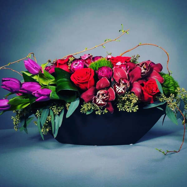 Red roses and purple tulips in a black container
