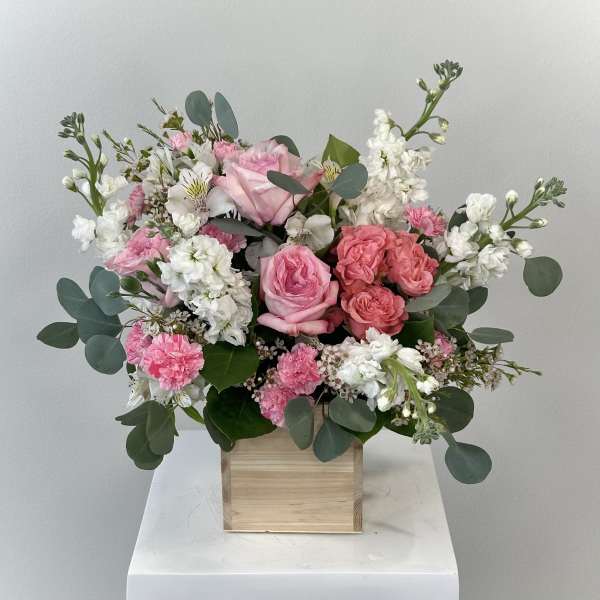 Pink and white floral arrangement in a wooden box