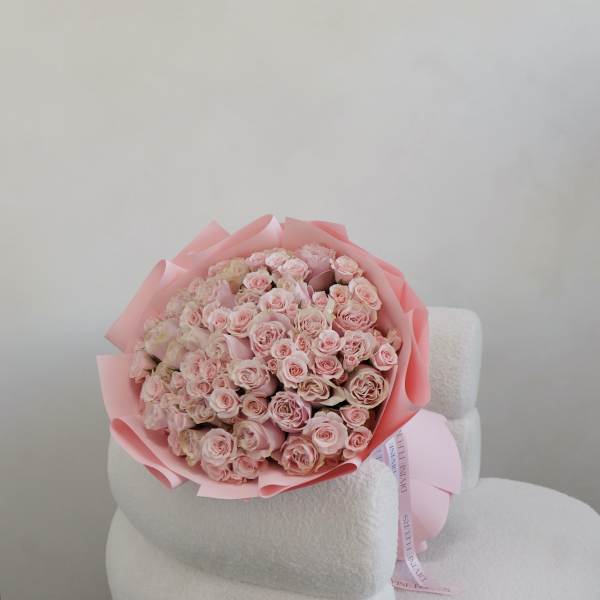 Bouquet of pale pink roses wrapped in pink paper
