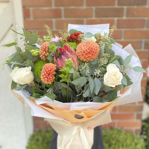 Bouquet of peach dahlias and white roses with greenery